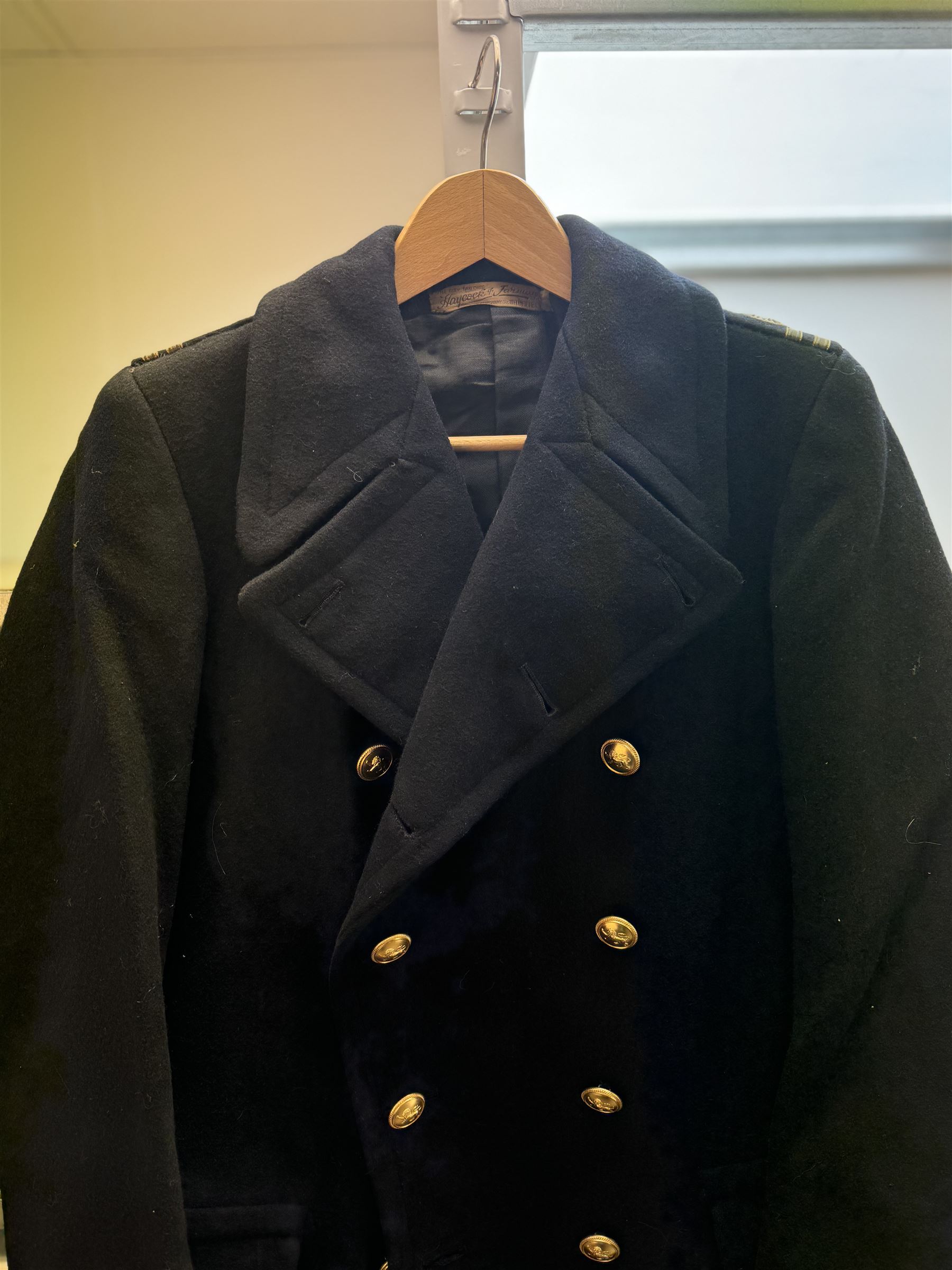 Royal Navy Lieutenant's Frock Coat by Haycock and Jarman, together with other naval accessories, including four pairs of Captain's insignia, six pairs of Captain's shoulder boards, a Merchant Navy cap badge and a collection of other badges, buttons and shoulder boards 