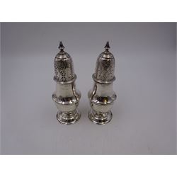 Pair of Victorian silver sugar casters, of typical waisted form, the removable pierced cover with urn finial, upon domed circular foot, hallmarked Sheffield 1880, maker's mark WB, H14.5cm