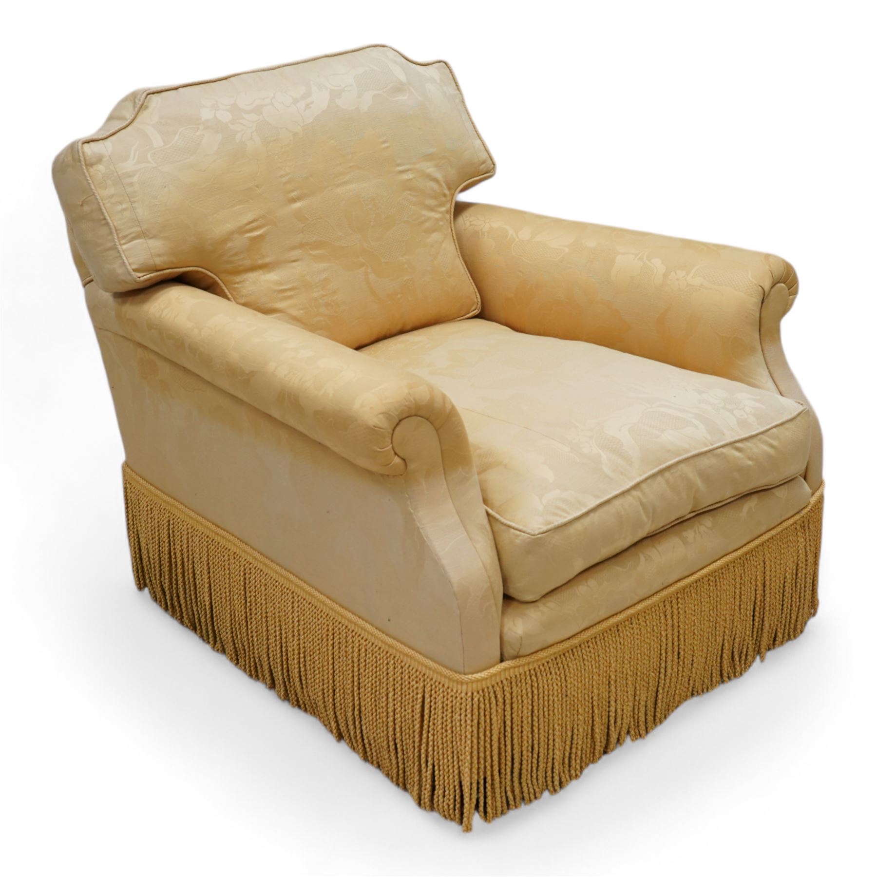 Early 20th century hardwood-framed armchair, shaped cresting over rolled arms, upholstered in floral pattern gold silk fabric with fringe, on turned front feet with recessed castors 