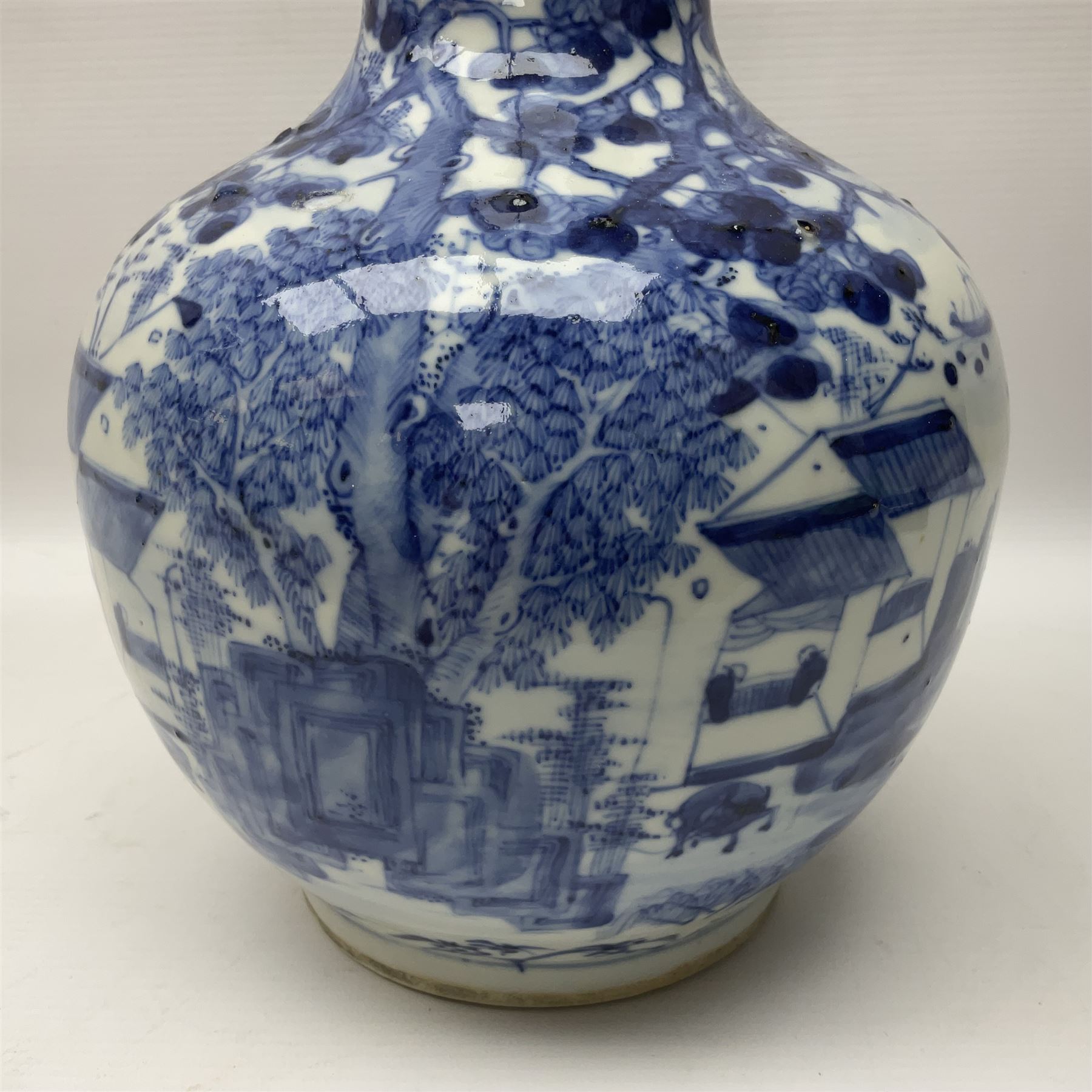 Late 18th/early 19th century Chinese blue and white bottle vase, decorated with a landscape scene containing dwellings, prunus and pine trees, boats and bridges, and populated with figures, with character mark beneath, H35cm