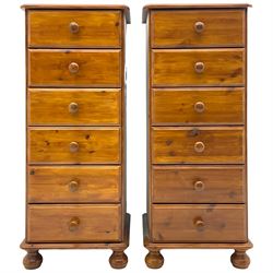 Pair of pine pedestal chests, fitted with six drawers, bun feet