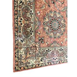 Persian design peach ground carpet, central floral medallion surrounded by scrolling foliage, decorated all over with stylised plant motifs, floral design repeating border