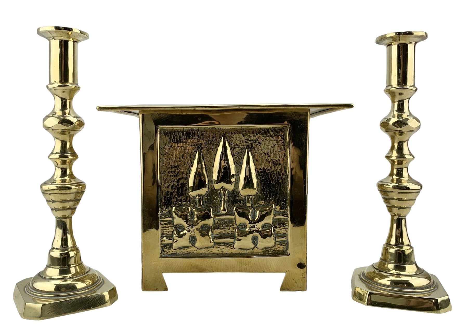 Arts and Crafts square brass planter, probably Glasgow School, with a raised pattern of stylised trees and foliage 23cm x 19cm and pair of brass candlesticks H25cm (3)