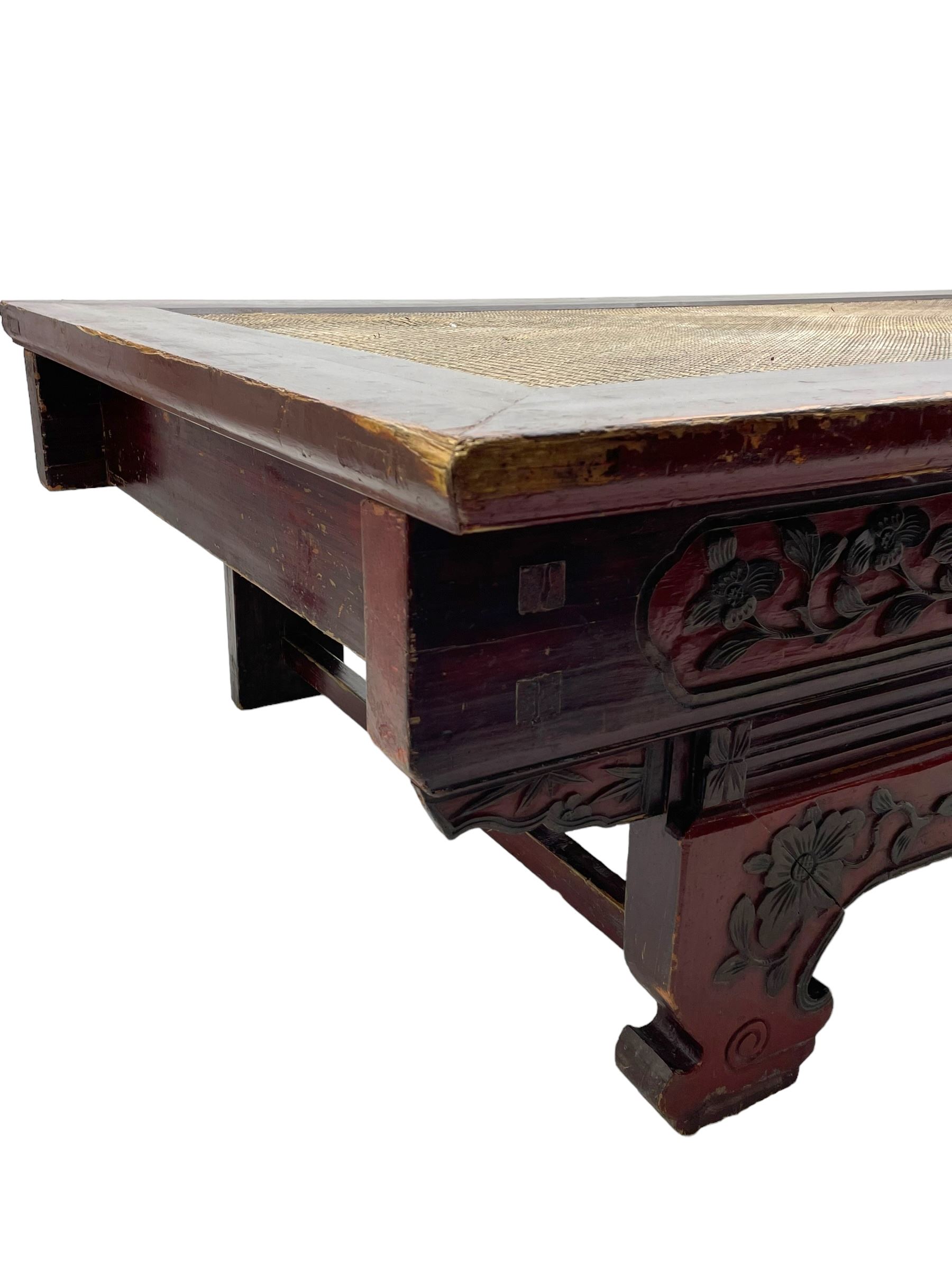 Mid-19th century Qing dynasty opium or wedding bed, Zhejiang province, rectangular top with weave cane work, the frieze rail carved with trailing leafy branches and flower heads, over moulded rail with small drawer, shaped base carved with further tailing foliate decoration terminating to shaped feet, united by stretchers 