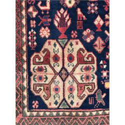 South West Persian Abadeh crimson ground rug, indigo ground with crimson lozenge field, decorated all over with small stylised motifs of flowerheads, hooks, animals and birds, guarded border decorated with trailing leaves and stylised plant motifs 