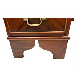 Late 20th century mahogany corner desk, leather inlaid top with gilt tooling, central frieze drawer flanked by two banks of four graduated drawers, raised on shaped bracket supports 