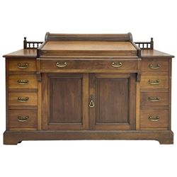 Victorian walnut clerk's desk, raised central section with tambour roll over hinged top, the interior fitted with leather inset writing surfaces, small drawers, document divisions and pen and ink stand, central drawer over double panelled cupboard, flanked by two banks of four graduating drawers, on bracket feet 