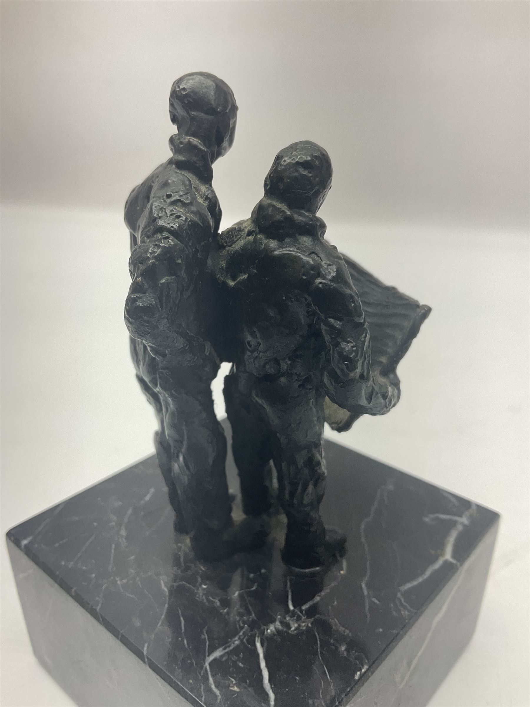 20th century bronze sculpture, modelled as two figures reading, upon a black and white marble base, H14cm