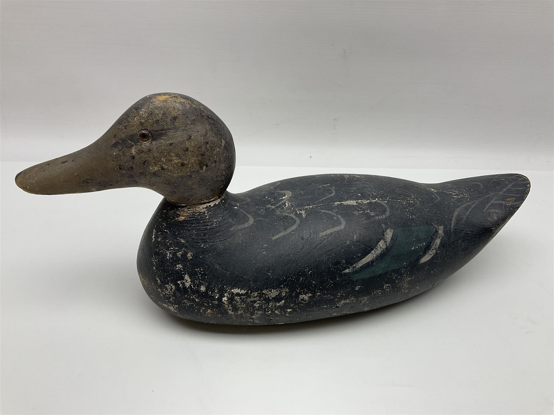 Early 20th century American carved wooden decoy duck, with weight beneath marked CJ Raymond Lead Co Chicago, Ill, H18cm, L38cm 