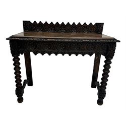 Victorian Gothic revival style carved oak console table, rectangular top with carved edge and raised back gallery, over deeply carved apron with floral and foliate motifs and central drawer, barley twist front supports and plain rear supports united by shaped stretchers, on front bun feet