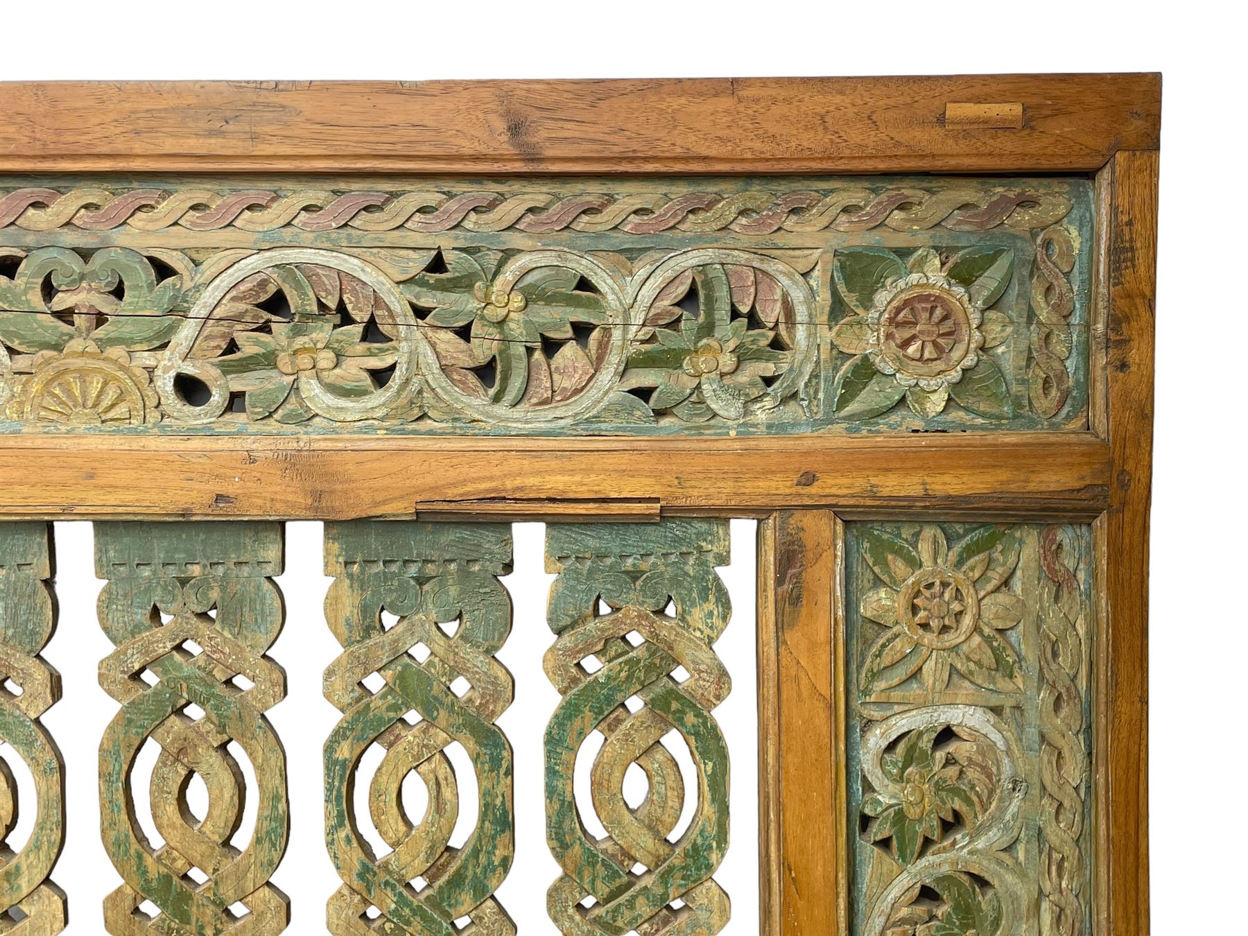 Early 20th century Javanese teak and hardwood door panel or room divider, rectangular panelled form with moulded frame and pegged construction, carved and pierced with scrolling decoration and flower head motifs, shaped and pierced splats with interlocking pattern