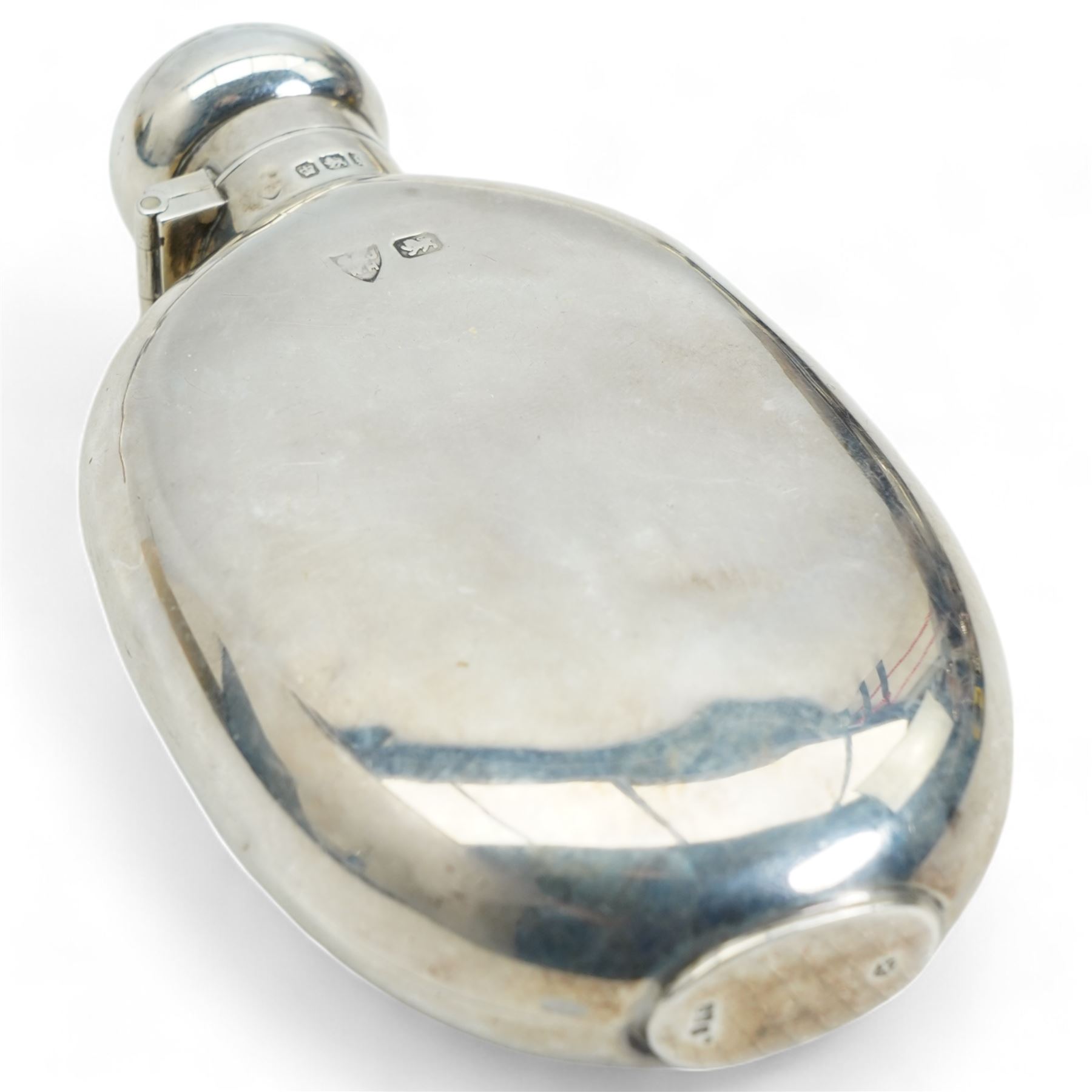 Silver oval spirit hip flask Sheffield 1899, engine turned silver square cigarette box, three piece silver backed dressing table set and three serviette rings 