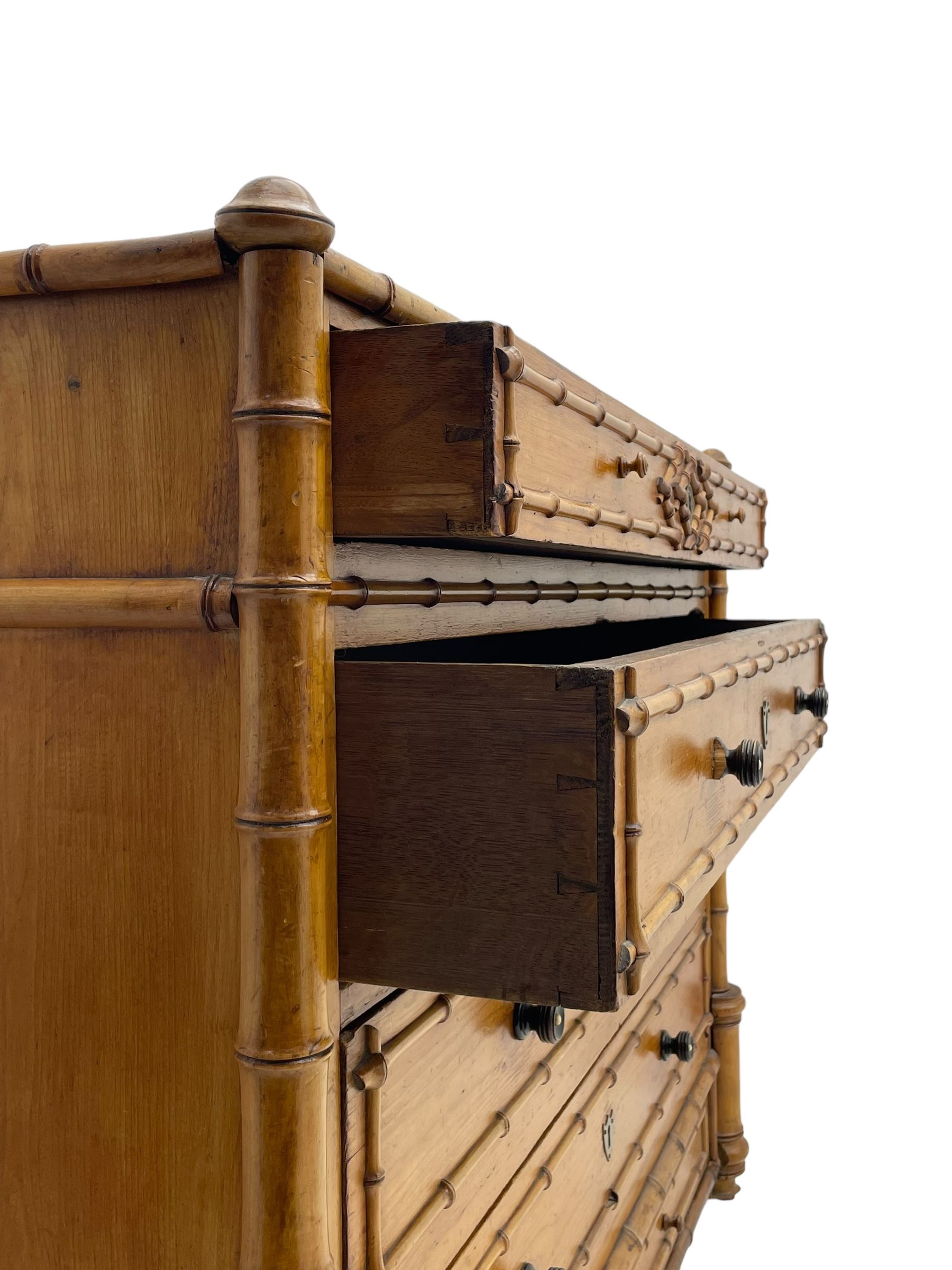 Victorian pine and simulated bamboo chest, fitted with five drawers, the drawer fronts decorated with applied simulated bamboo mounts and turned ebonised handles, on turned front feet