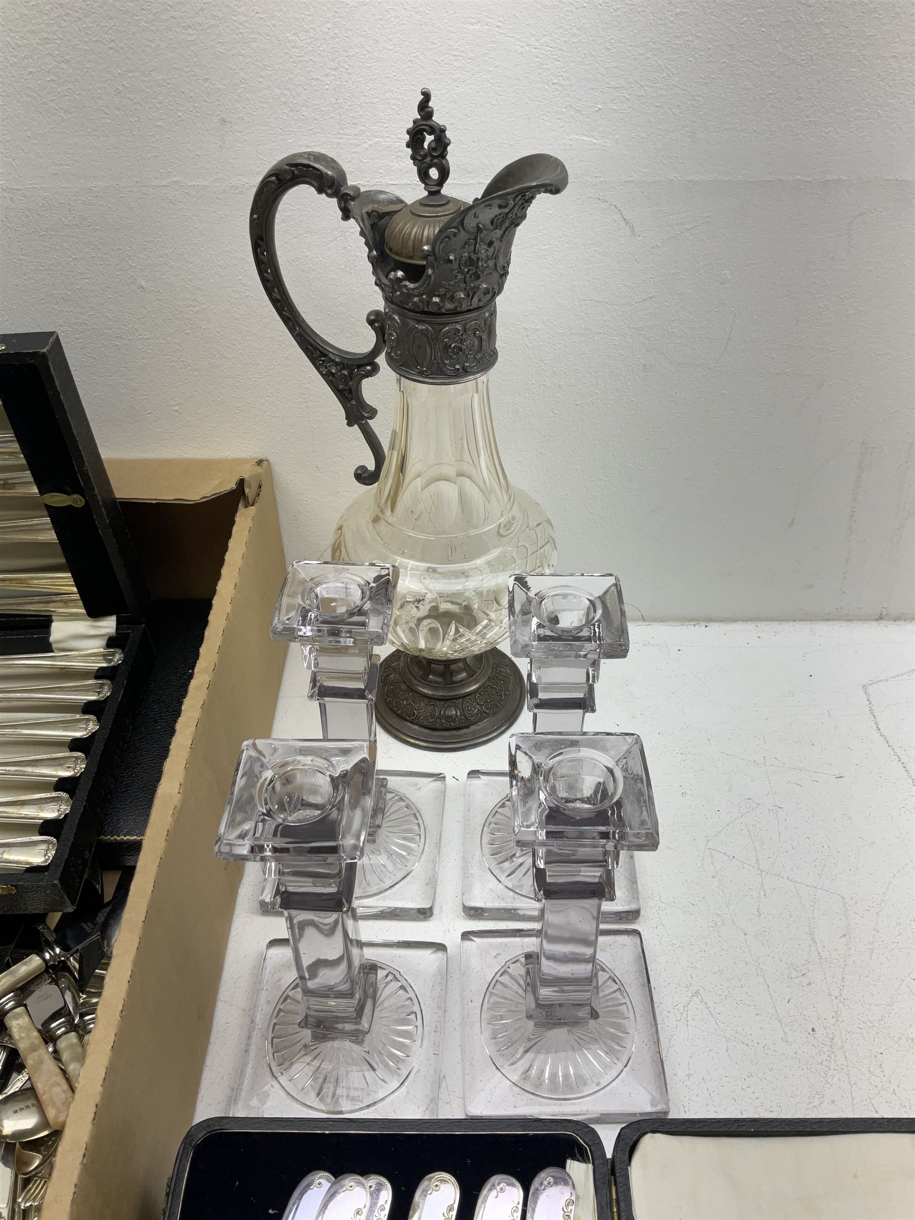 Metal mounted clear glass claret jug, together with a set of four clear glass candlesticks, and a group of assorted silver plated flatware, to include a number of sets, some cased, in one box 