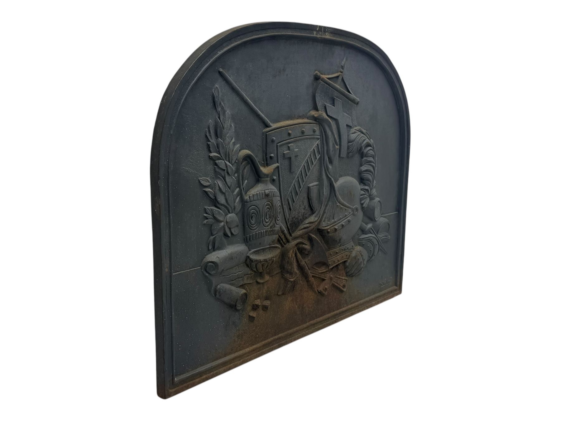 French cast iron fireback, arched form with relief of medieval armour and heraldic symbols, including a shield with a cross and a plumed helmet