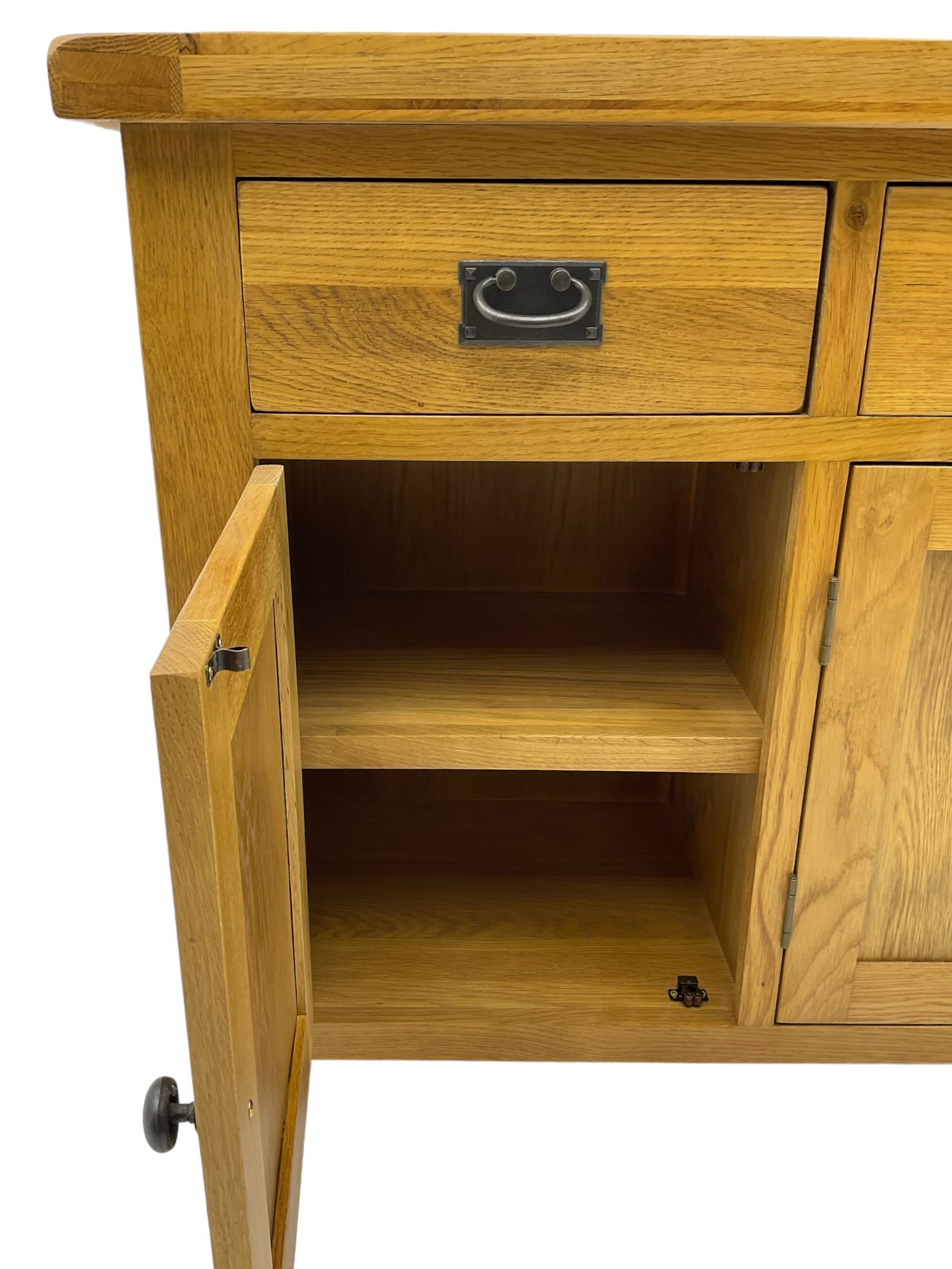 Contemporary light oak sideboard, fitted with three drawers over three panelled cupboards enclosing shelving, on square supports