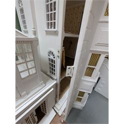 Large three storey modern dolls house, painted white with latticed windows, grey roof and metal fencing, with decorated interior, together with two dolls house garden rooms and two conservatories