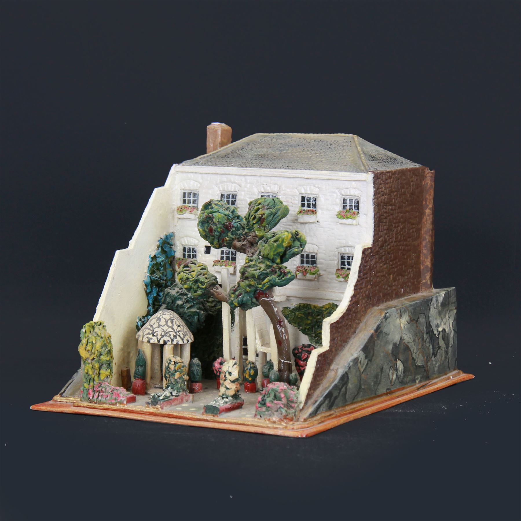 Mixed medium sculpture of house and garden, with makers mark beneath, H15cm