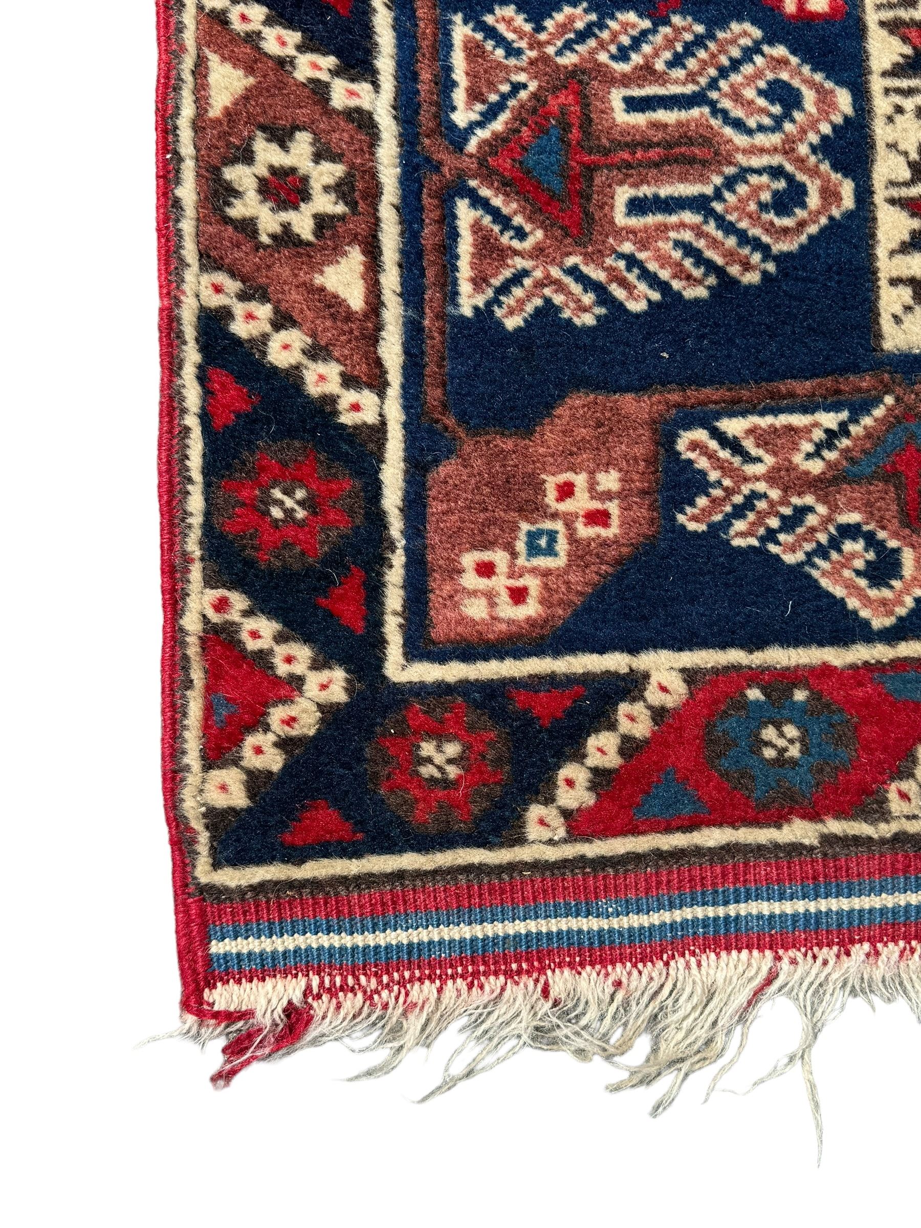 Turkish crimson ground rug, the field decorated with three geometric medallions within a band of star motifs, the main border decorated with stylised plant motifs 