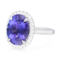 18ct white gold oval cut tanzanite and round brilliant cut diamond cluster ring, with diamond set shoulders, hallmarked, tanzanite 5.83 carat, total diamond weight 0.54 carat