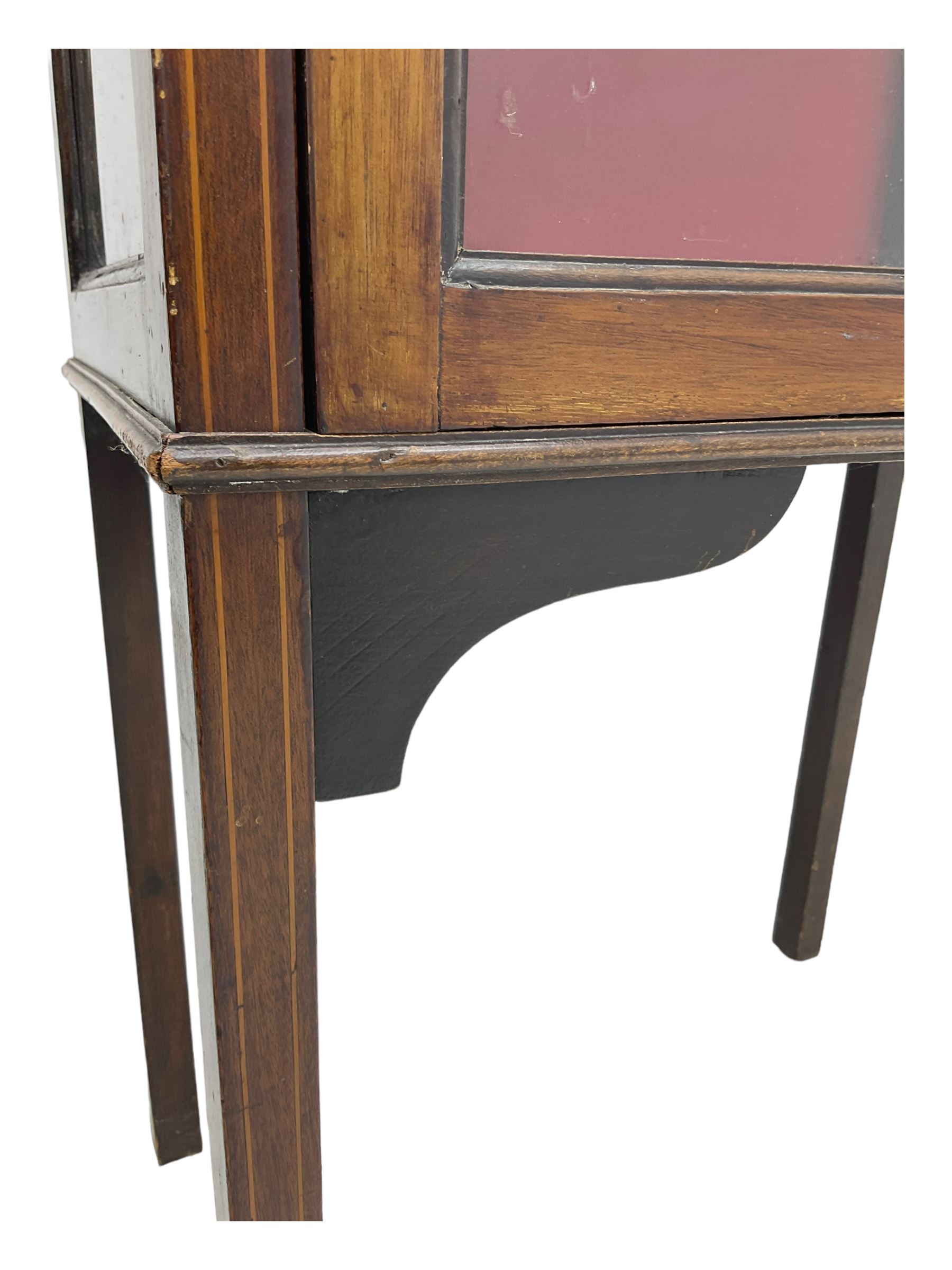 Early 20th century mahogany display cabinet, projecting moulded cornice over inlaid frieze, single astragal glazed door opening to reveal three felt-lined shelves, raised on square tapering supports