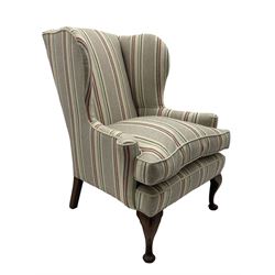 Georgian design hardwood-framed wingback armchair, curved wingback terminating to curved and rolled arms, upholstered in striped fabric with loose seat cushion, on cabriole front feet 