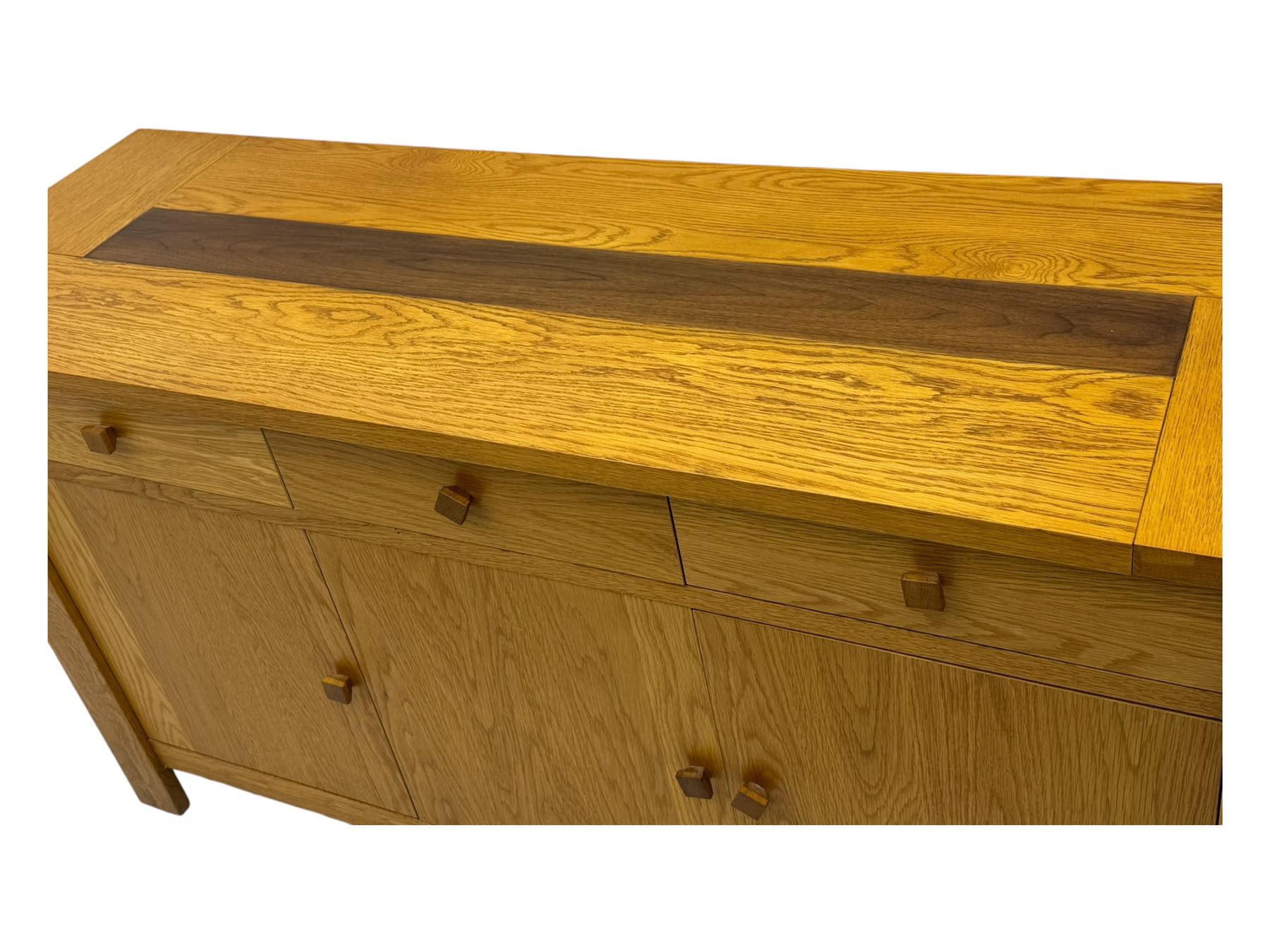 Contemporary oak sideboard, rectangular top with central contrasting plank, over three frieze drawers and three cupboards with enclosed shelving, on rectangular stile supports