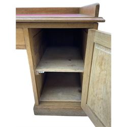 20th century oak desk, moulded rectangular top with raised back and inset leather writing surface, fitted with five drawers and single panelled cupboard, on moulded plinth base