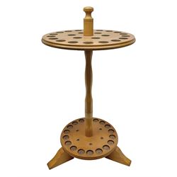 Pine stick stand, with turned central column dividing two circular tiers, upon three feet, with capacity for twenty four walking sticks, H73cm