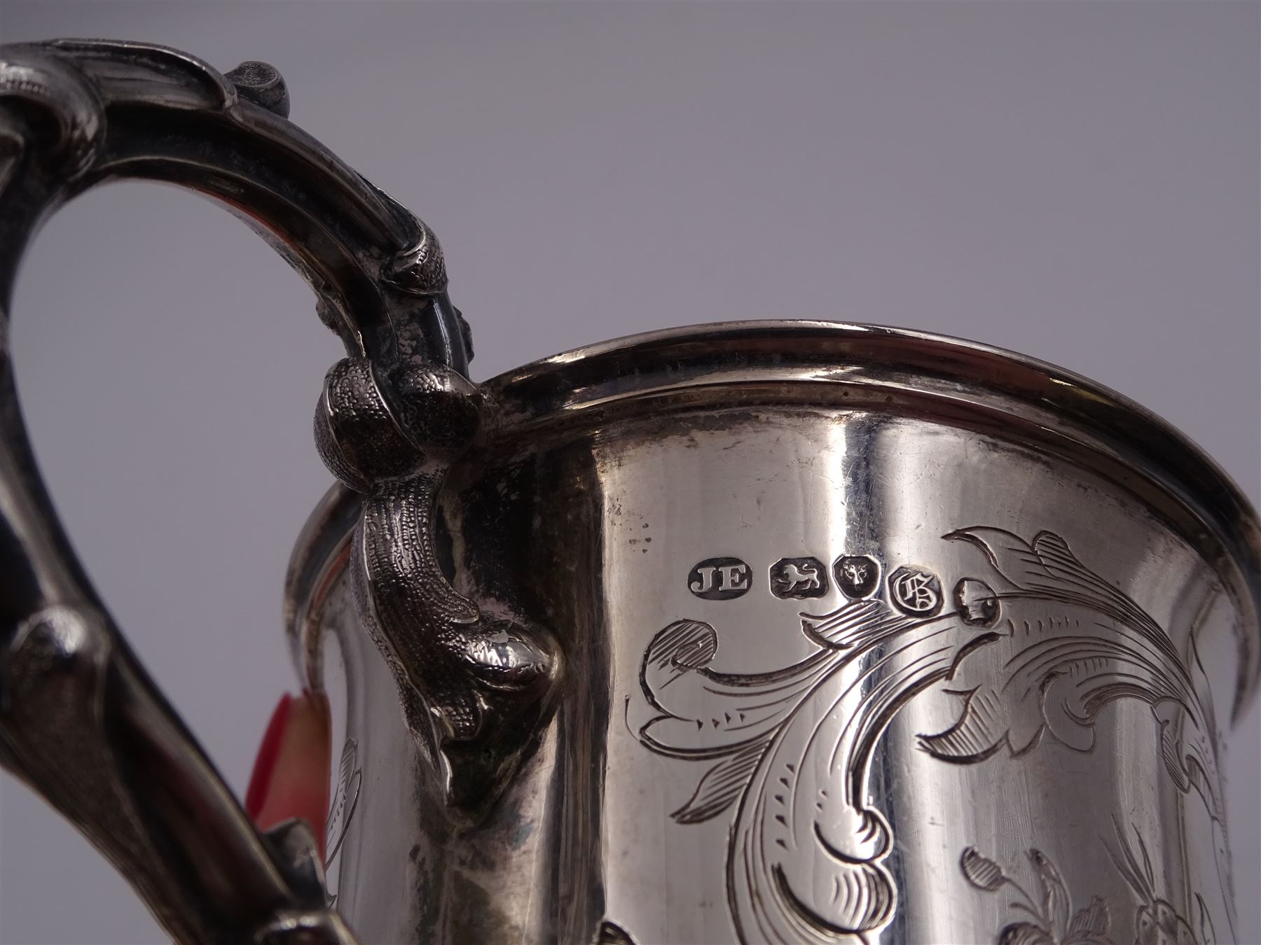 Victorian silver christening mug, of cylindrical form with fluted rim, gilt interior and acanthus capped C scroll handle, the body with later engraved decoration and initials, with embossed scroll base, hallmarked John Evans II, London 1840, including handle H10.2cm