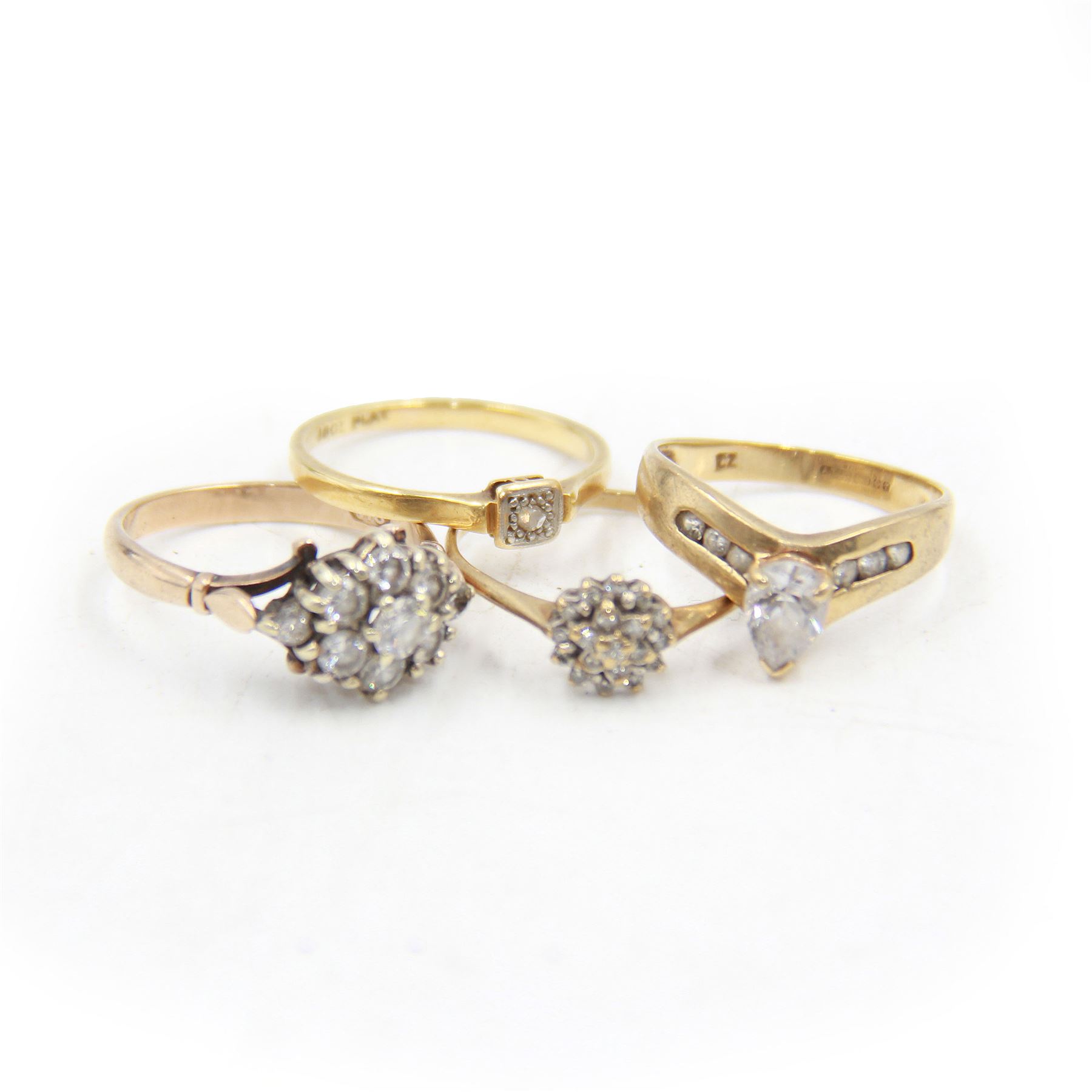 Four 9ct gold stone set rings, to include a diamond flower cluster ring, cubic zirconia wishbone ring and two others, all stamped or hallmarked