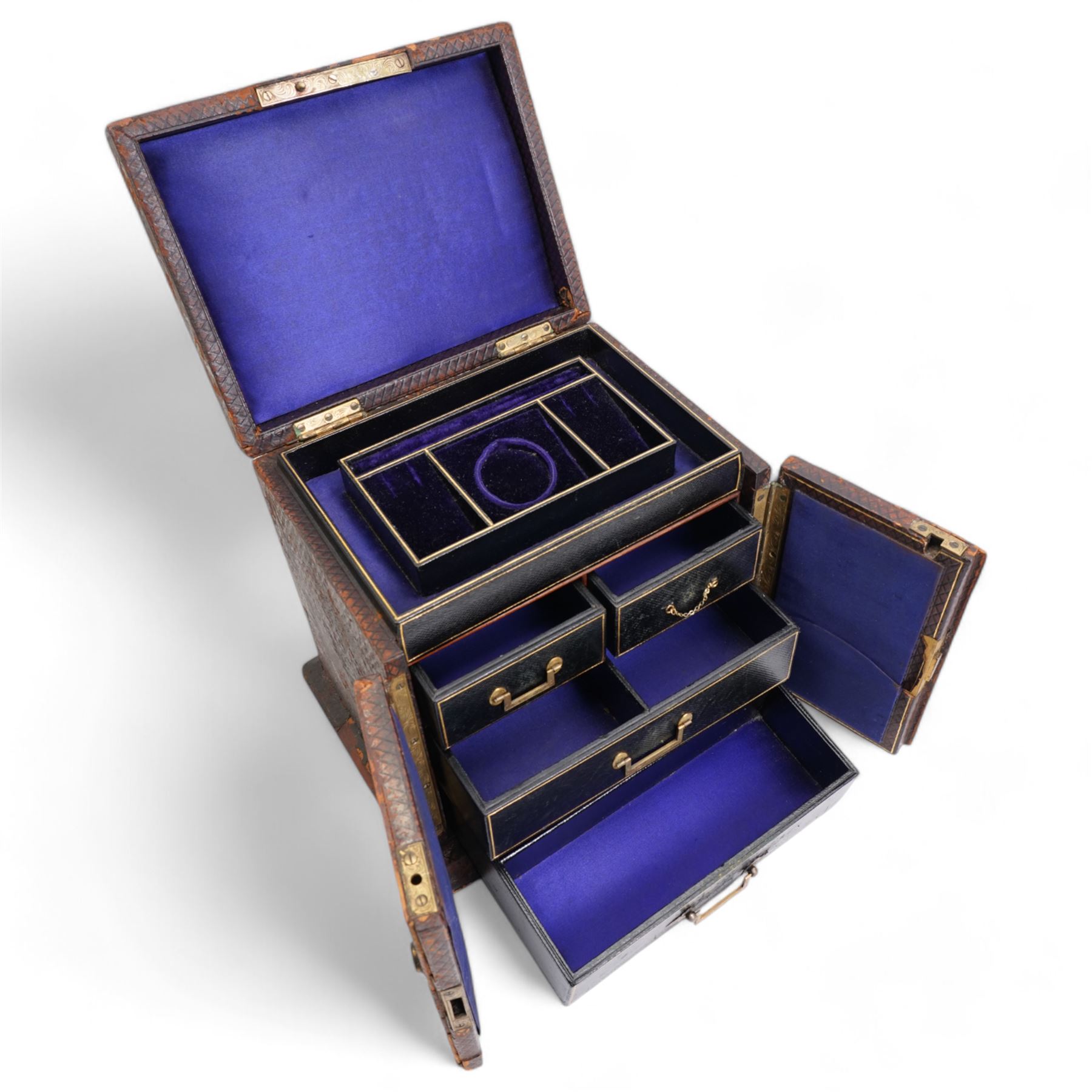 Victorian tooled leather jewellery casket, the cover with inset brass handle, two hinged doors open to reveal a top inset lined tray and central pocket watch, above two short and two long drawers, H22cm, W24.5cm, D19.5cm 