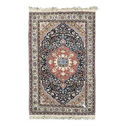 Indo-Persian indigo ground rug, the floral design peach medallion surrounded by trailing and interlaced branches and flower heads, the main border decorated with repeating stylised plant motifs within floral guard stripes 