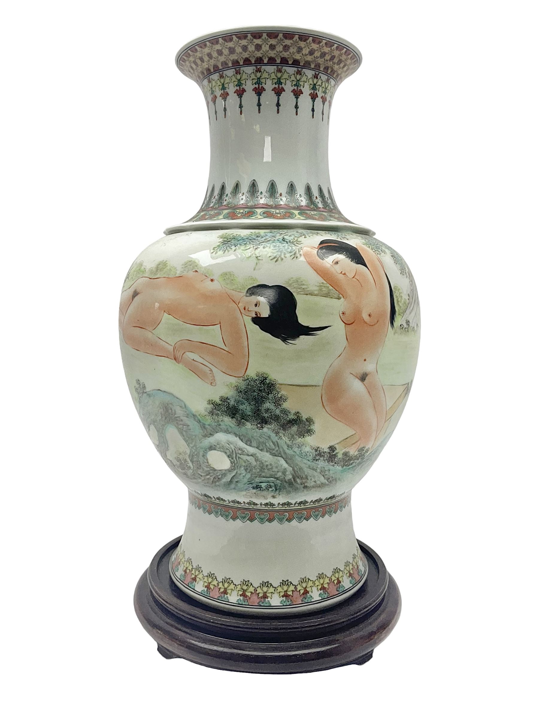 Chinese famille verte vase, of baluster form with fluted rim, the body decorated with five nude female figures amongst water and trees, with bands of polychrome foliate and floral decoration to base and rim, with six character Qianlong mark beneath, upon a circular wooden base, H41.5cm