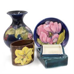 Moorcroft vase in Clematis pattern, together with small vase in Bermuda Lily pattern, Hibiscus pattern trinket box and Magnolia pattern trinket dish, all with makers mark beneath, vase H13cm
