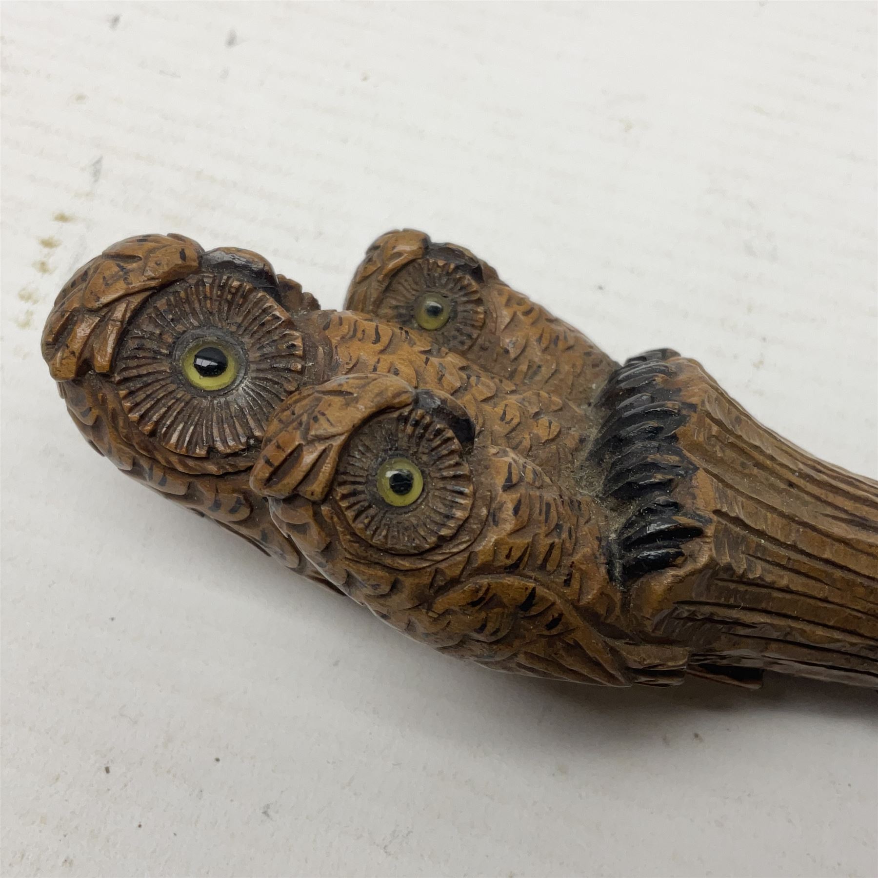 Late 19th/early 20th century Black Forest style carved walking stick handle, modelled as three owls with glass eyes, H9cm