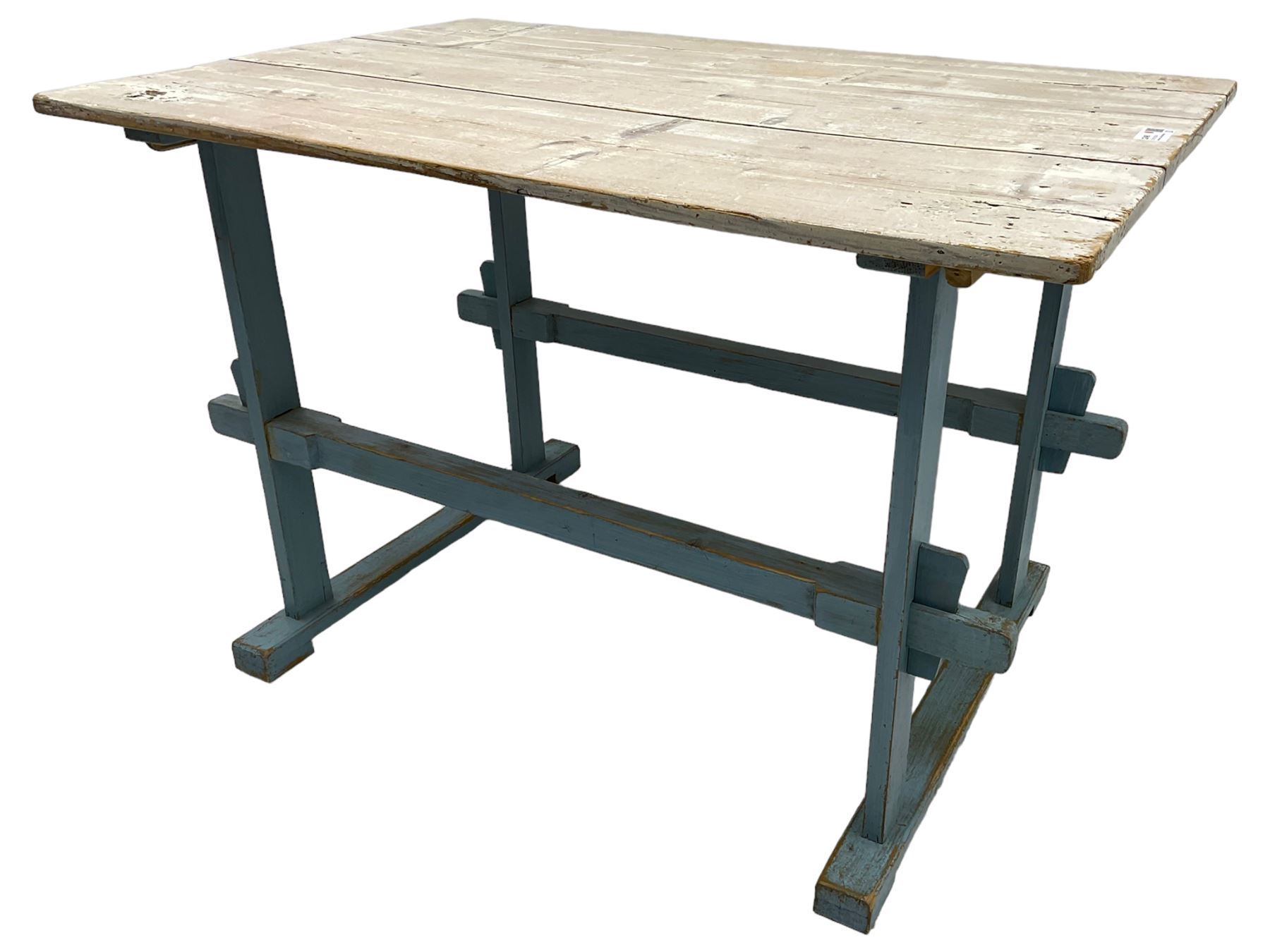 Early 20th century pine rustic dining table, rectangular plank top with weathered patina, over trestle-style supports in distressed blue paint with central stretcher