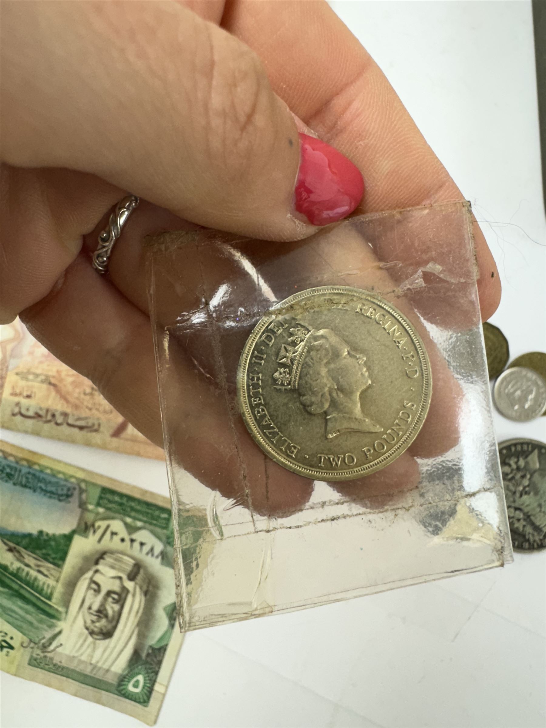 Various coins and banknotes including two Morgan dollars, in a vintage tin