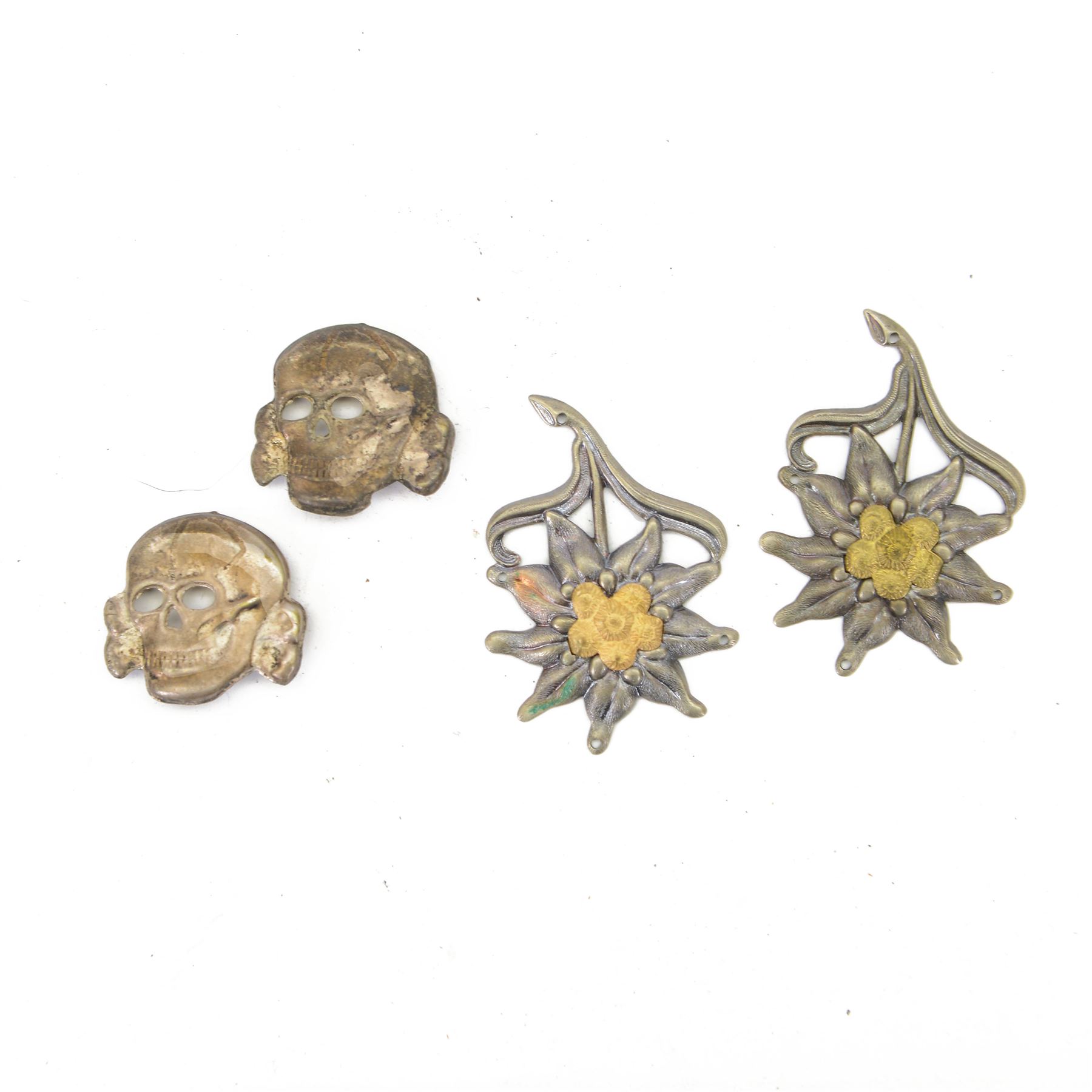 WWII German, four cap badges, comprising of two SS skulls, and two Edelweiss mountain badges, skulls H3cm, mountain L5cm