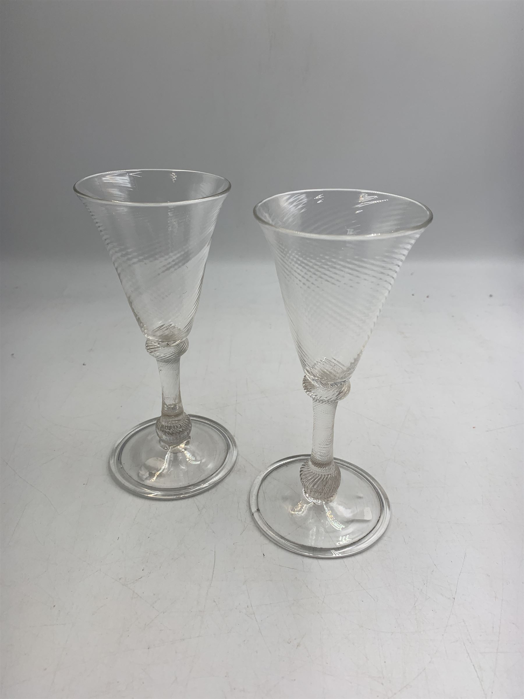 Pair of 18th century Liege wine glasses, circa 1730, with wrythen fluted trumpet bowls and knopped stems, H14.5cm