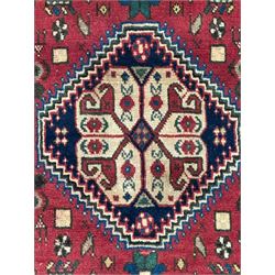 South West Persian Abadeh crimson ground rug, indigo ground with crimson lozenge field, decorated all over with small stylised motifs of flowerheads, hooks, animals and birds, guarded border decorated with trailing leaves and stylised plant motifs 