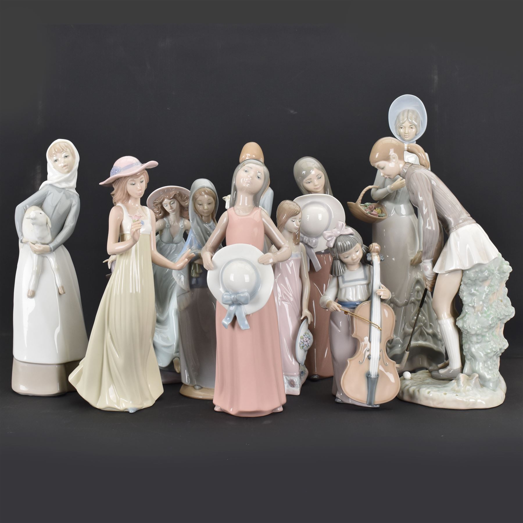 Group of Lladro figures, to include May Dance no 5662, examples modelled as a female golfer, young woman holding sheep in her arms, pair of figures in pink dressed holding sun hats, etc., together with two Nao figures and a further Spanish example, (11)