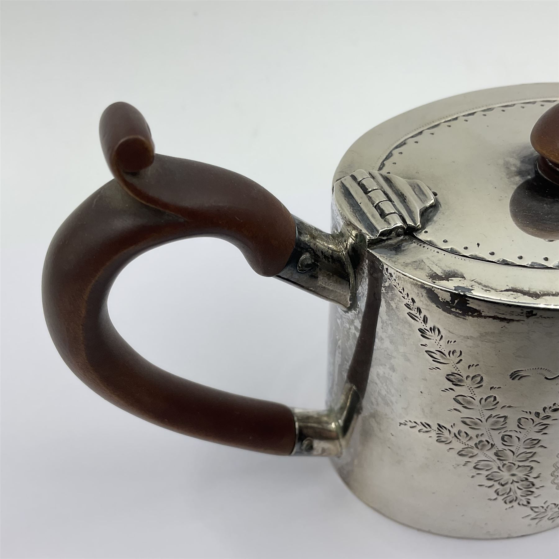 George III silver bachelors teapot, of oval form with wooden scroll handle and finial, the body chased with armorial crest and ribbon swag and foliate detail, hallmarked Samuel Godbehere & Edward Wigan, London 1793, including handle H9cm