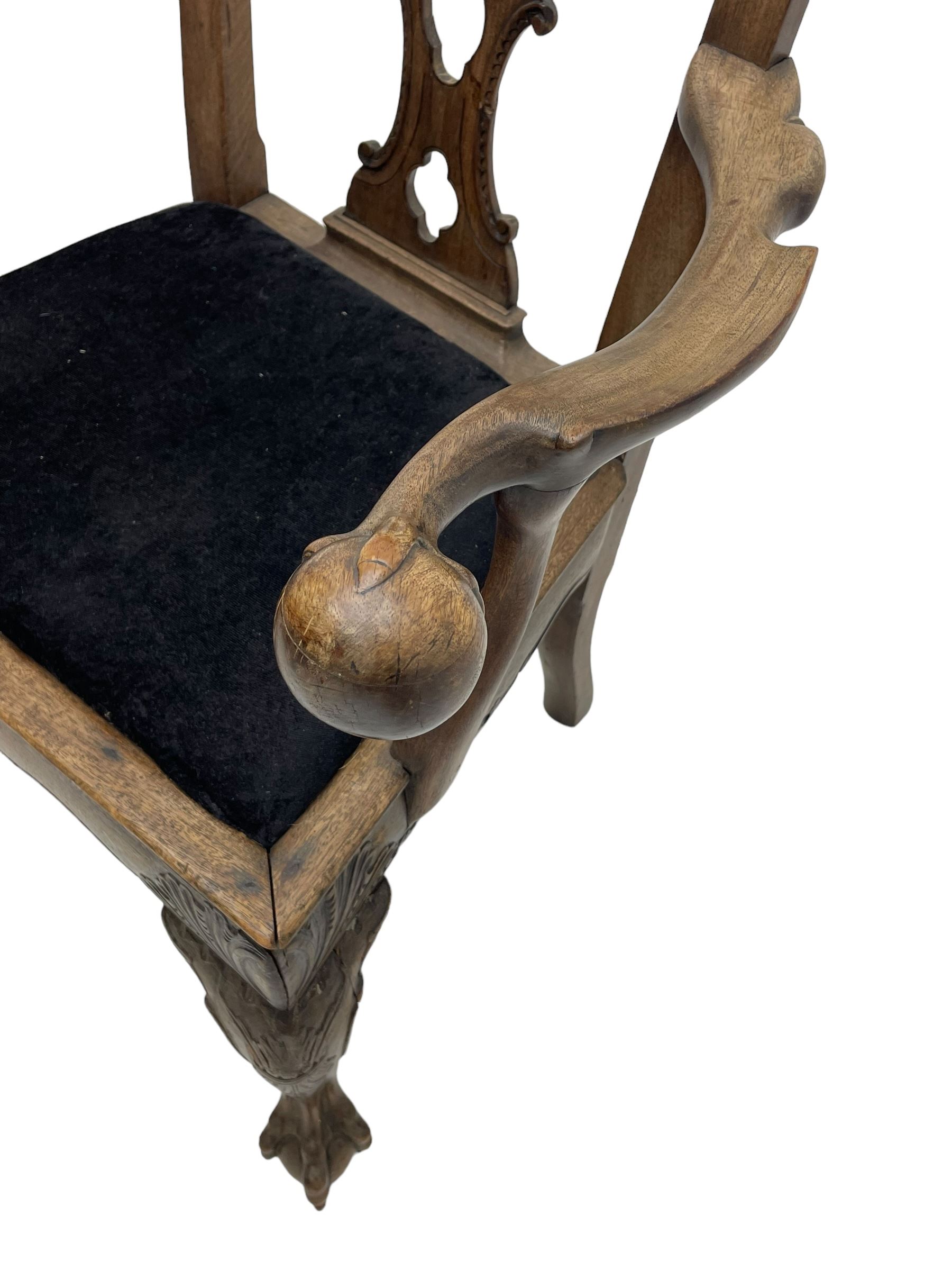 Unusual 18th century mahogany elbow chair, the shaped cresting rail with projecting shell carved ears, pierced and scroll carved splat over drop-in upholstered seat, shaped arms with ball and claw carved terminals, the seat rails carved with shell cartouches, on foliate carved cabriole supports with ball and claw feet 