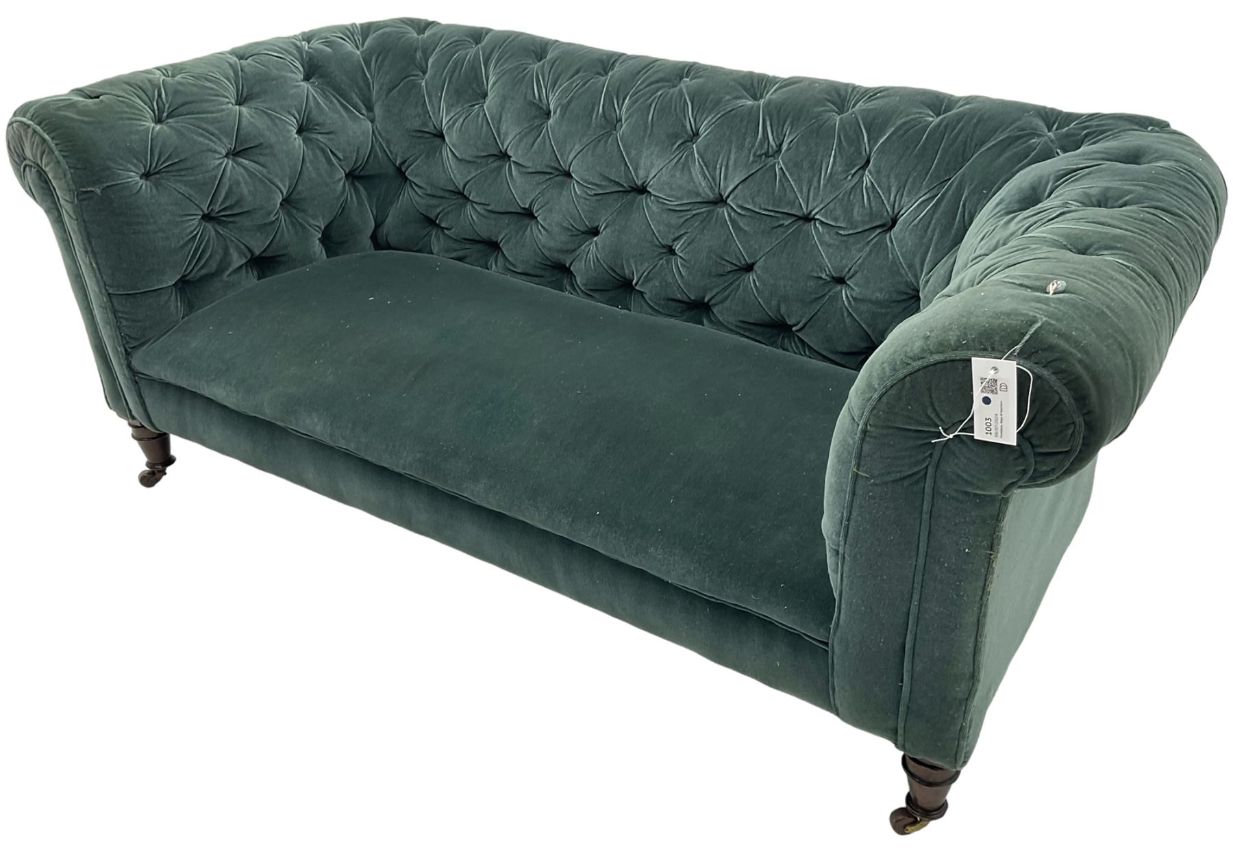 Victorian hardwood-framed Chesterfield sofa, traditional shape with low back and rolled arms, upholstered in teal buttoned fabric, on turned front feet with brass and ceramic castors 