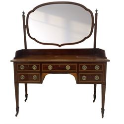 Edwardian inlaid mahogany kneehole dressing table, raised shaped oval bevelled mirror back, fitted with five drawers with banding and stringing, on square tapering supports with castors