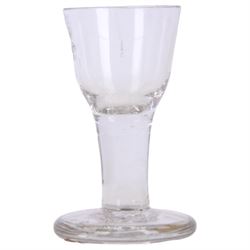 Three 18th century drinking glasses, the first example with rounded bowl engraved with foliate sprigs and border to rim, upon a short double series opaque twist stem and thick foot, H10cm the second with ogee part fluted bowl upon a short plain stem and thick stepped foot, H9cm, and the third toastmaster example with rounded funnel bowl upon a plain stem and thick firing foot, H11cm 