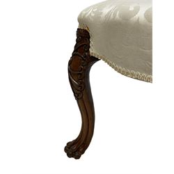 Georgian Irish mahogany dressing stool, overstuffed seat upholstered in in ivory damask fabric, the cabriole supports decorated with moulded interlacing scroll motifs with mycelium cap detail, over lobe carvings terminating to large paw feet