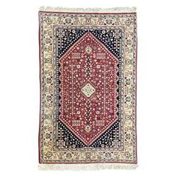 Persian design crimson ground rug, the field decorated with tree of life and floral motifs...