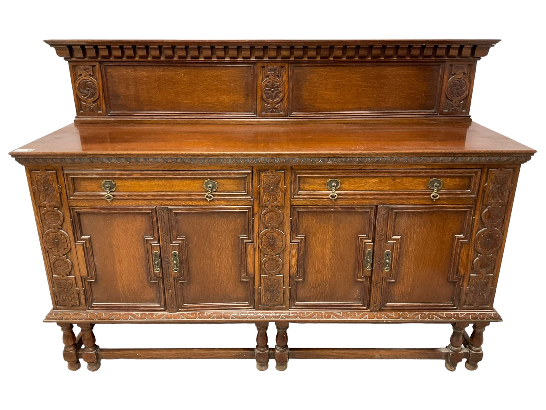 Early 20th century oak sideboard, raised panelled back with foliate carved decoration, rectangular top with gadrooned edge, fitted with two drawers over cupboards with field moulded facias, turned supports joined by stretchers